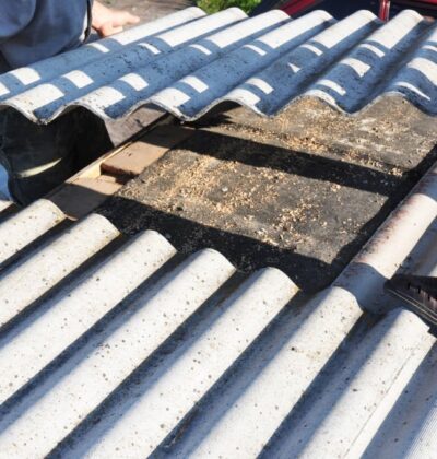 Asbestos workers repair asbestos roof. Asbestos removal.
